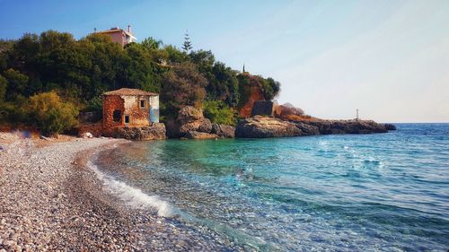 Scenic view of sea by building against sky