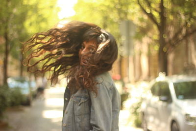 Young woman standing on tree trunk