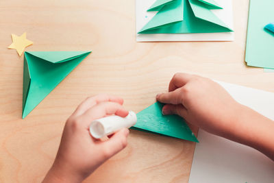 High angle view of baby hand holding paper