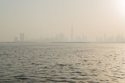 Scenic view of river and buildings against sky in city