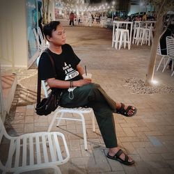 Full length of young man sitting on chair