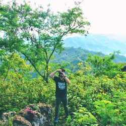 Man standing by tree against sky