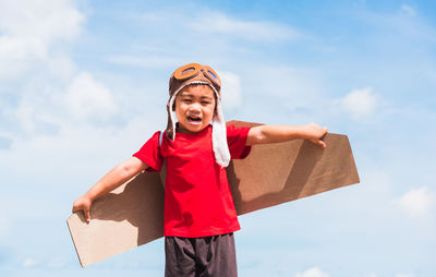 Smiling boy playing against sky outdoors