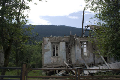 Built structure by trees against sky