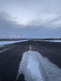 Surface level of road against sky during winter