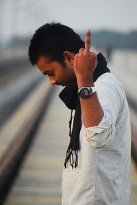 Side view of man showing middle finger