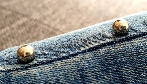 Close-up of buttons on blue fabric jeans