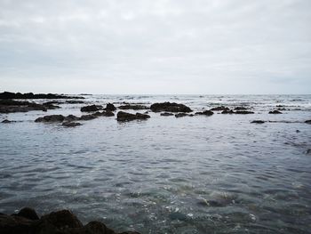 Scenic view of rocks in sea against sky