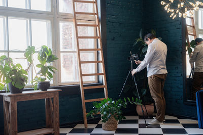 Side view of man looking through window