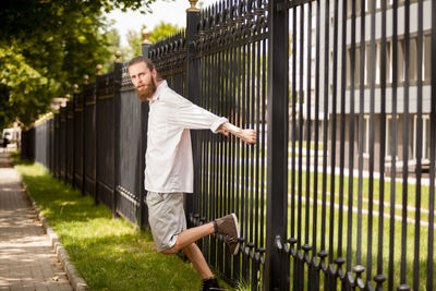 Full length of man standing against fence