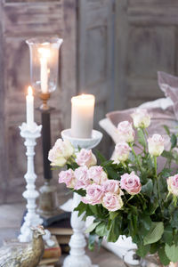 Bouquet of pink roses and burning candles