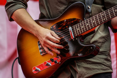 Midsection of man playing guitar