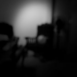 Defocused image of silhouette people standing on table