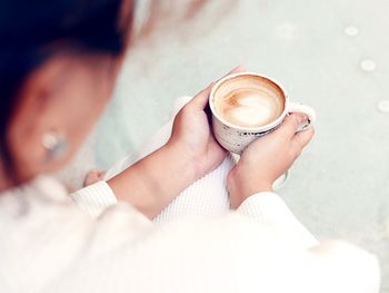 High angle view of woman holding coffee cup