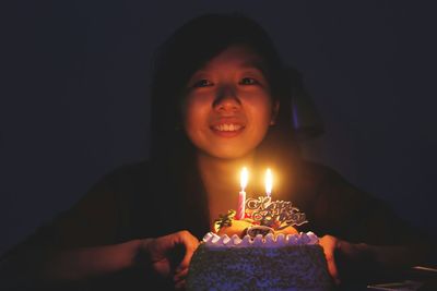 Portrait of young woman looking away over black background