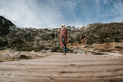 Man standing on mountain against sky