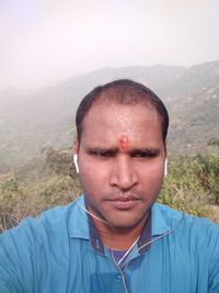 Portrait of young man against landscape