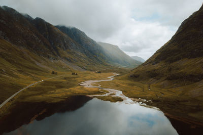 Scenic view of lake by mountains against sky