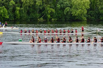 People rowing on lake during competition