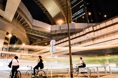 People riding bicycles on street in city at night