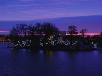 Reflection of trees in water at dusk