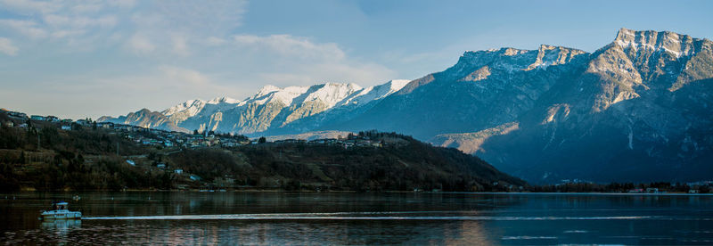 Scenic view of lake and snowcapped mountains against sky