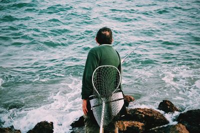 Rear view of man looking at sea