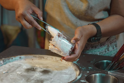 Close-up of woman preparing food on table