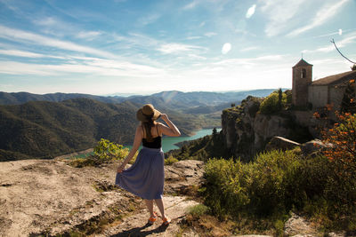 Rear view of woman standing at siurana against sky