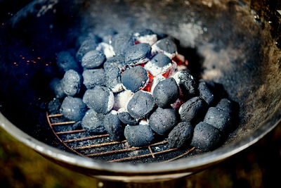 Closeup of glowing coal in metal grill on summer day in the garden