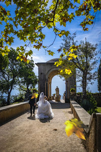 Rear view of couple walking in front of building