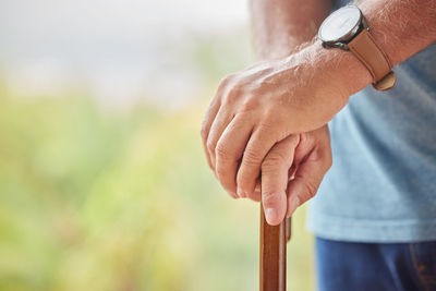 Midsection of man holding thermometer