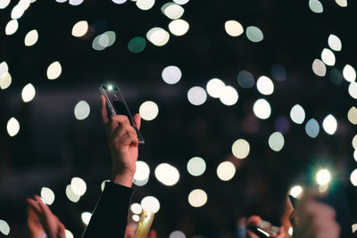 Close-up of hand holding smart phone at night