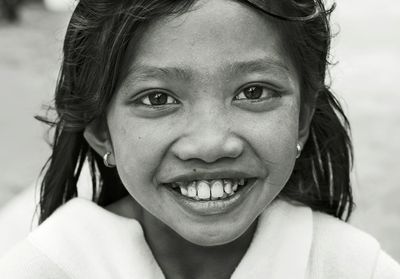 Close-up portrait of smiling girl standing outdoors