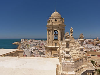 Historic building by sea against clear sky