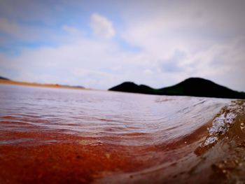 Scenic view of river against cloudy sky