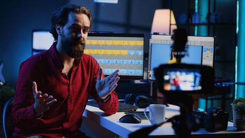 Side view of young man using laptop at cafe