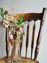 Close-up of flower vase on table against wall