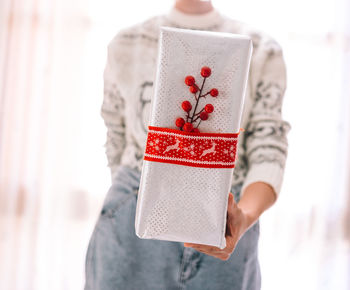 Midsection of woman holding christmas gift