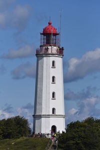 Low angle view of lighthouse by building against sky