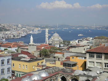 High angle view of townscape by sea against sky