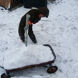 Person standing on snow covered field during winter