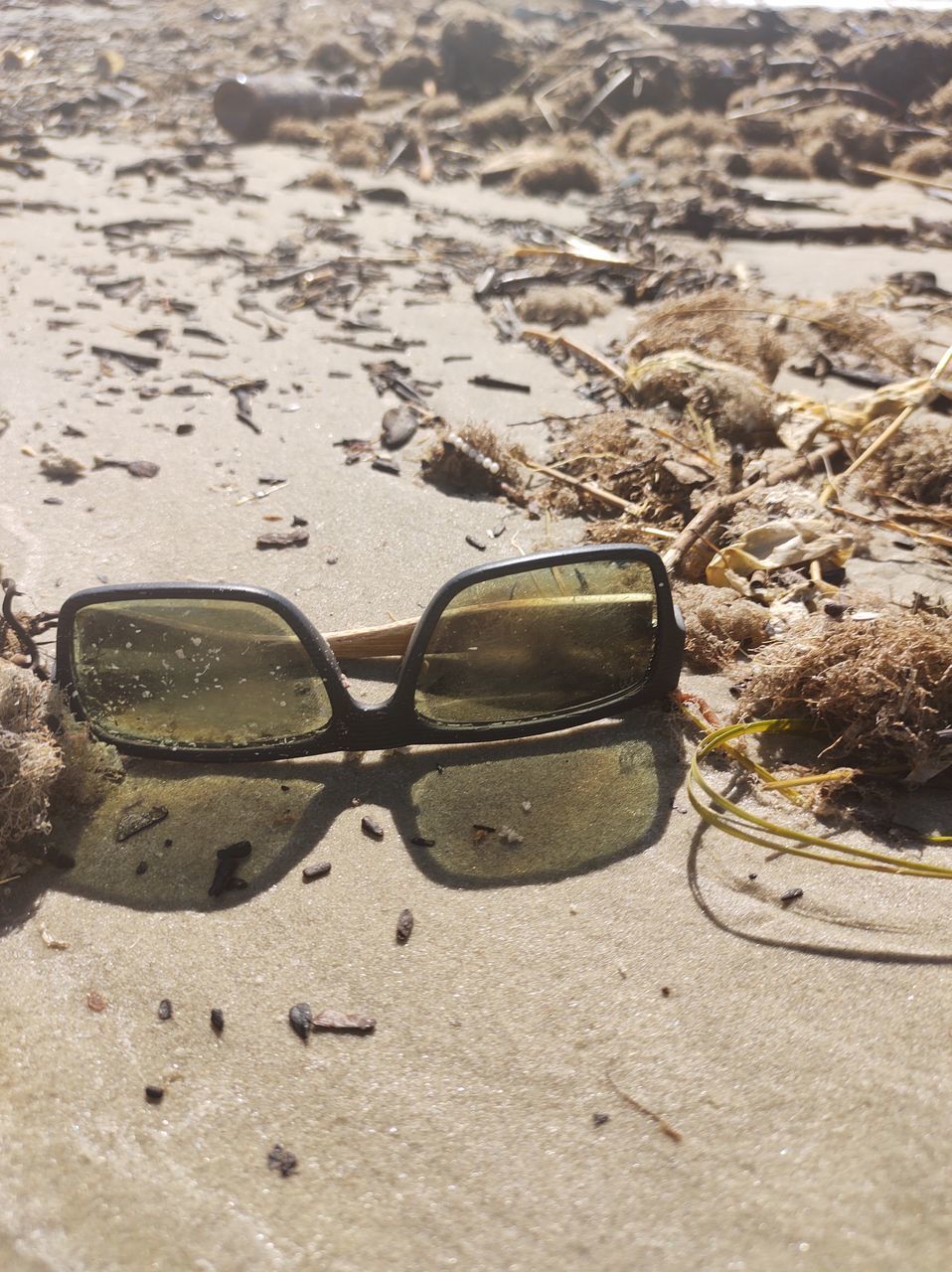 SURFACE LEVEL OF SUNGLASSES ON BEACH