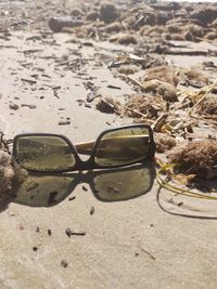 Close-up of sunglasses on beach