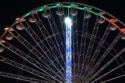 Low angle view of illuminated ferris wheel against sky at night