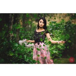 Portrait of woman standing against plants