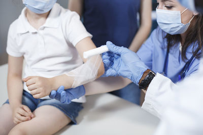 Midsection of doctor examining patient in hospital