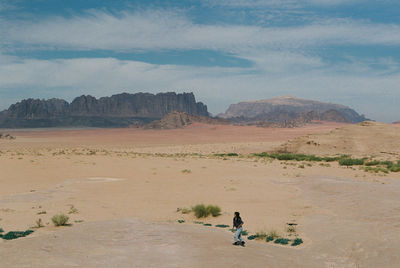 Man cycling on mountain against sky