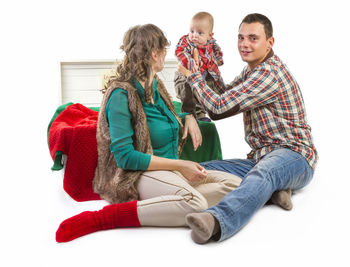Low section of people sitting against white background