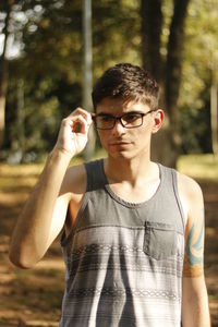 Thoughtful man wearing eyeglasses at forest